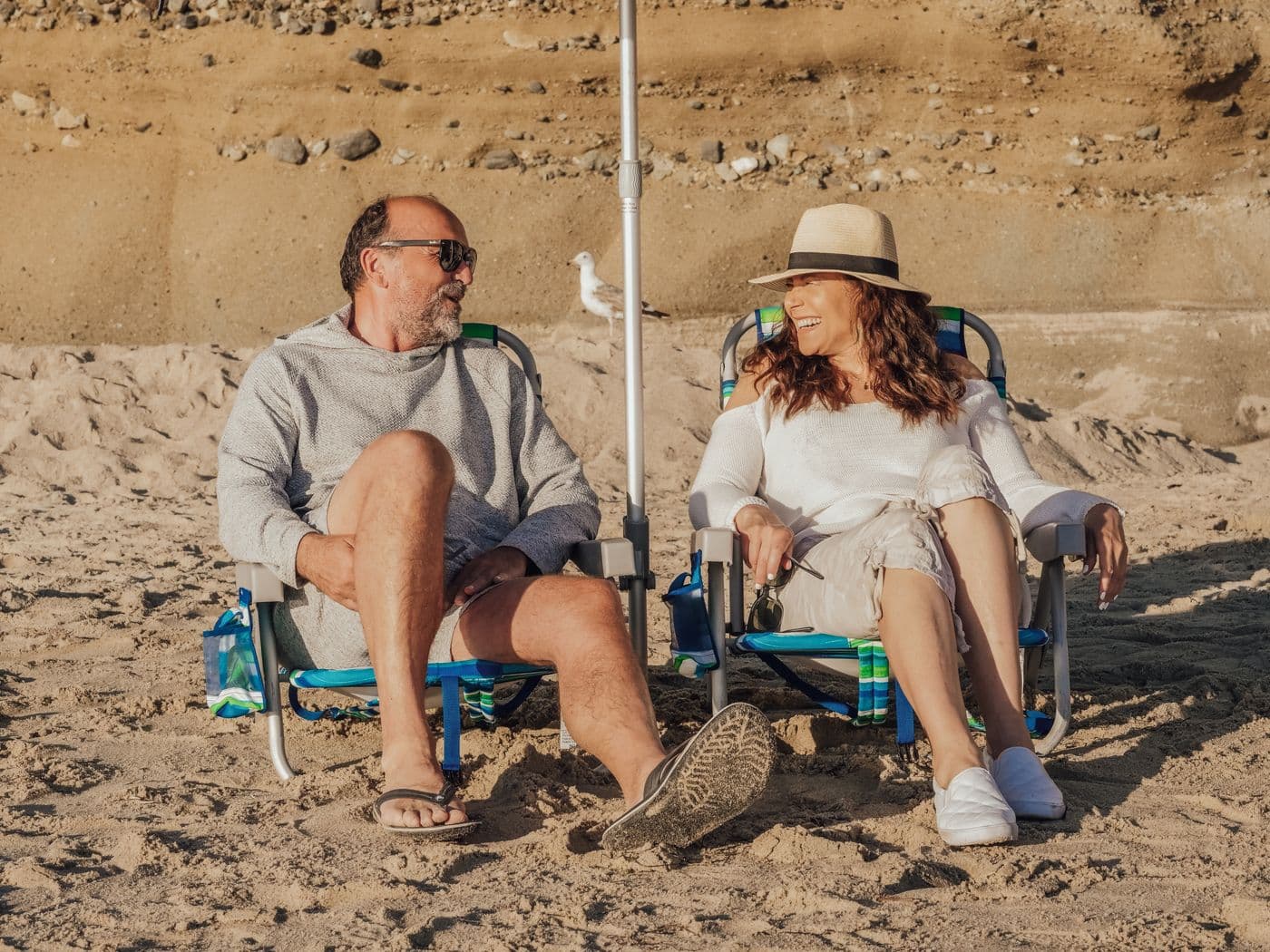 An older couple laughing together on a sunny beach