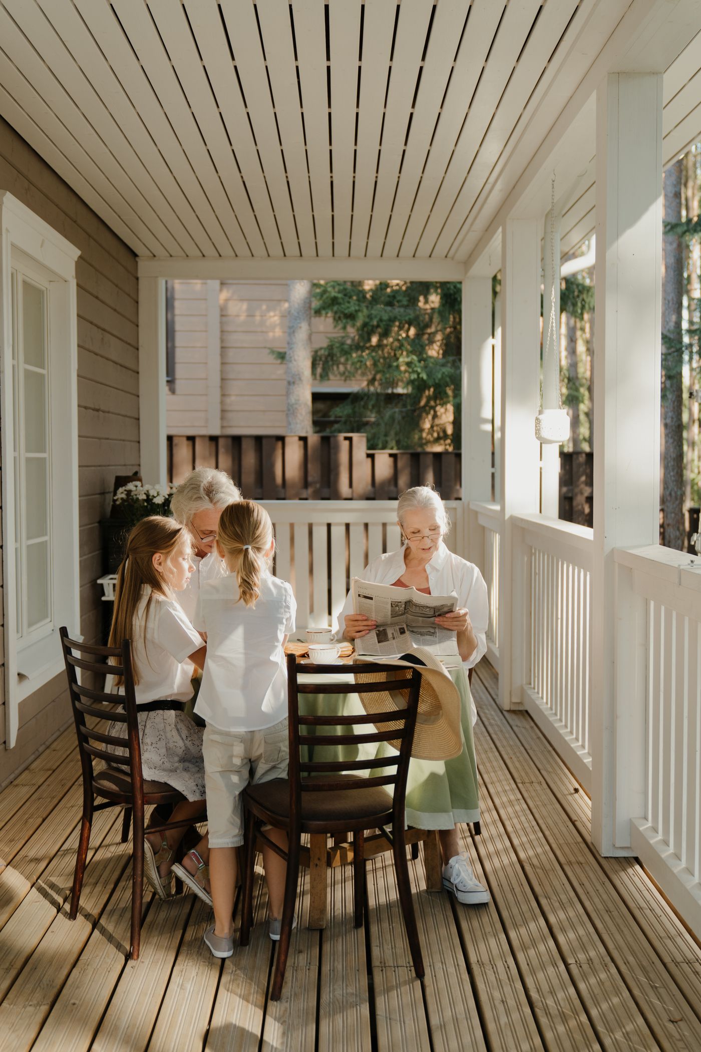 Grandparents and grandchildren sharing a relaxed morning together on a sunny veranda, family legacy and connection